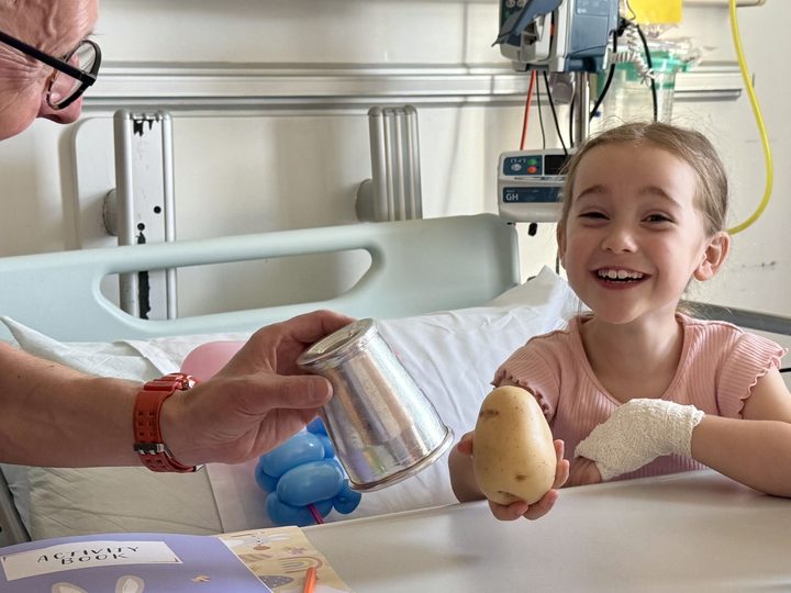 Smiling girl with magician's cup-and-potato trick